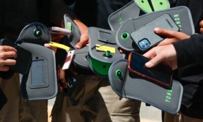 Students using locked smartphone pouches in a classroom