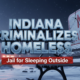 A viral, hyper-realistic YouTube thumbnail with a dramatic winter night atmosphere. The background is a frozen Indiana city park covered in snow with abandoned tents half-buried under drifts and faint police lights in the distance. The composition uses a low-angle shot looking up at a massive cracked concrete "NO CAMPING" sign bolted to a park bench. The image features massive 3D typography with strict hierarchy: The Primary Text reads exactly: 'INDIANA CRIMINALIZES HOMELESS'. This text is massive, rendered in cold blue chrome with ice crystals forming on the letters. The Secondary Text reads exactly: 'Jail for Sleeping Outside'. This text is smaller, in urgent red with a thick white outline and subtle warning-tape texture. The text materials correspond to the story's concept. Crucial Instruction: There is absolutely NO other text, numbers, watermarks, or subtitles in this image other than these two specific lines. 8k, Unreal Engine 5, cinematic render.