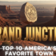 A viral, hyper-realistic YouTube thumbnail with a warm Western American adventure atmosphere. The background is a dramatic Colorado National Monument canyon at golden hour with deep red rock formations and the Grand Junction skyline faintly visible in the valley below. The composition uses a low-angle heroic shot to focus on the main subject: a massive polished granite stone engraved with the city seal floating above the canyon rim. The image features massive 3D typography with strict hierarchy: The Primary Text reads exactly: 'GRAND JUNCTION'. This text is massive, the largest element in the frame, rendered in molten sunset gold chrome to look like a high-budget 3D render. The Secondary Text reads exactly: 'TOP 10 AMERICA'S FAVORITE TOWN'. This text is significantly smaller, positioned below the main text with a thick white glow border and subtle lens flare effect. Make sure text 2 has completely different style and border compared to text 1. The text materials correspond to the story's concept. Crucial Instruction: There is absolutely NO other text, numbers, watermarks, or subtitles in this image other than these two specific lines. 8k, Unreal Engine 5, cinematic render