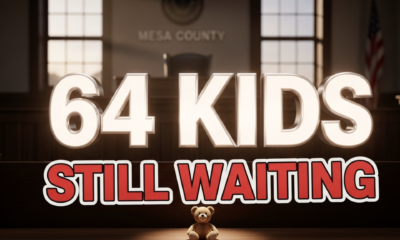 A viral, hyper-realistic YouTube thumbnail with a dramatic, heartfelt atmosphere. The background is a dimly lit Mesa County courtroom with soft Colorado sunset light streaming through windows. The composition uses a low, child's-eye camera angle looking up toward the empty witness chair. The main subject: a single empty child's teddy bear sitting alone on the wooden courtroom bench, gently spotlit. The image features massive 3D typography with strict hierarchy: The Primary Text reads exactly: '64 KIDS'. This text is massive, rendered in glowing white chrome with soft inner light like hope. The Secondary Text reads exactly: 'STILL WAITING'. This text is smaller, positioned below in bold red with thick black outline sticker style. The text materials correspond to the story's concept. Crucial Instruction: There is absolutely NO other text, numbers, watermarks, or subtitles in this image other than these two specific lines. 8k, Unreal Engine 5, cinematic render