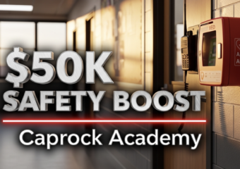 A viral, hyper-realistic YouTube thumbnail with a serious protective atmosphere. The background is a modern school hallway in Grand Junction Colorado at golden hour with warm sunlight streaming through new safety windows. The composition uses a dramatic low-angle shot to focus on the main subject: a sleek black two-way radio and a red AED unit mounted on the wall beside a classroom door with fresh one-way privacy film. The image features massive 3D typography with strict hierarchy: The Primary Text reads exactly: '$50K SAFETY BOOST'. This text is massive, the largest element in the frame, rendered in brushed steel chrome to look like a high-budget 3D render. The Secondary Text reads exactly: 'Caprock Academy'. This text is significantly smaller, positioned below the main text. It features a thick, glowing red border/outline to contrast against the background. Make sure text 2 is always different theme, style, effect and border compared to text 1. The text materials correspond to the story's concept. Crucial Instruction: There is absolutely NO other text, numbers, watermarks, or subtitles in this image other than these two specific lines. 8k, Unreal Engine 5, cinematic render