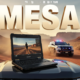 A viral, hyper-realistic YouTube thumbnail with a high-tech desert law enforcement atmosphere. The background is a dramatic Western Colorado red-rock canyon at golden hour with a Mesa County Sheriff patrol truck kicking up dust in the distance, emergency lights flashing. The composition uses a low-angle cinematic shot to focus on the main subject: a rugged Panasonic TOUGHBOOK 55 laptop dramatically open on the hood of a sheriff SUV, screen glowing bright with body-cam footage playing. The image features massive 3D typography with strict hierarchy: The Primary Text reads exactly: 'MESA COUNTY'. This text is massive, the largest element in the frame, rendered in brushed gunmetal chrome with orange emergency-light reflections to look like a high-budget 3D render. The Secondary Text reads exactly: 'DROPS $764K ON 5G'. This text is significantly smaller, positioned below the main text. It features a thick, glowing neon-orange border/outline (sticker style) to contrast against the desert background. Make sure text 2 is always different theme, style, effect and border compared to text 1. The text materials correspond to the story's concept. Crucial Instruction: There is absolutely NO other text, numbers, watermarks, or subtitles in this image other than these two specific lines. 8k, Unreal Engine 5, cinematic render