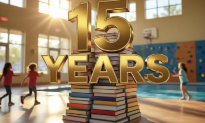 A viral, hyper-realistic YouTube thumbnail with a warm, golden-hour community atmosphere. The background is the sunlit lobby of Fruita Community Center with blurred kids running toward the climbing wall and pool light dancing on the floor. The composition uses a low-angle cinematic shot to focus on the main subject: a towering stack of colorful library books morphing into a basketball hoop. The image features massive 3D typography with strict hierarchy: The Primary Text reads exactly: '15 YEARS'. This text is massive, the largest element in the frame, rendered in polished gold chrome with subtle light flares to look like a high-budget 3D render. The Secondary Text reads exactly: 'Fruita Library + Rec Center'. This text is significantly smaller, positioned below the main text. It features a thick white sticker-style outline with slight red glow to contrast against the background. The text materials correspond to the story's concept. Crucial Instruction: There is absolutely NO other text, numbers, watermarks, or subtitles in this image other than these two specific lines. 8k, Unreal Engine 5, cinematic render.