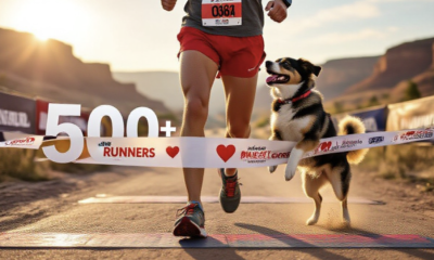 A viral, hyper-realistic YouTube thumbnail with a warm, romantic outdoor sports atmosphere.eabaground is the sun-lit Fruita Community Center finish line area with Colorado River bluffs in the distance and soft golden morning light. The composition uses a wide, slightly low angle to focus on the main subject: a pair of muddy running shoes mid-stride with a red heart-shaped race bib pinned to red shorts, a happy rescue dog leaping up for a kiss right at the finish line tape. The image features massive 3D typography with strict hierarchy: The Primary Text reads exactly: '500+ RUNNERS'. This text is massive, the largest element in the frame, rendered in polished chrome with red glowing edges to look like a high-budget 3D render. The Secondary Text reads exactly: 'SWEETHEART RUN RECORD'. This text is significantly smaller, positioned below the main text. It features a thick white sticker-style border with slight drop shadow to contrast against the background. Make sure text 2 is always different theme, style, effect and border compared to text 1. The text materials correspond to the story's concept. Crucial Instruction: There is absolutely NO other text, numbers, watermarks, or subtitles in this image other than these two specific lines. 8k, Unreal Engine 5, cinematic render.