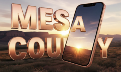 A viral, hyper-realistic YouTube thumbnail with a hopeful, warm Western Colorado sunrise atmosphere. The background is a sweeping Grand Junction landscape with the Book Cliffs glowing in golden morning light and subtle lens flare. The composition uses a dramatic low angle to focus on the main subject: a glowing, three-dimensional smartphone floating in mid-air, screen facing camera. The image features massive 3D typography with strict hierarchy: The Primary Text reads exactly: 'MESA COUNTY'. This text is massive, the largest element in the frame, rendered in polished rose-gold chrome with subtle Colorado red rock texture to look like a high-budget 3D render. The Secondary Text reads exactly: 'FIXES MENTAL HEALTH'. This text is significantly smaller, positioned below the main text with thick white outline and soft blue glow border to pop against the sunrise sky. Make sure text 2 is always different theme, style, effect and border compared to text 1. The text materials correspond to the story's concept. Crucial Instruction: There is absolutely NO other text, numbers, watermarks, or subtitles in this image other than these two specific lines. 8k, Unreal Engine 5, cinematic render