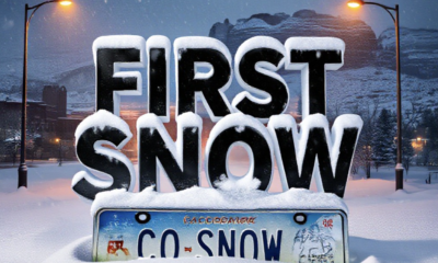 A viral, hyper-realistic YouTube thumbnail with a dramatic winter storm atmosphere. The background is a dark, moody Grand Junction skyline at night with heavy snow swirling under orange streetlights and the Colorado National Monument barely visible through the blizzard. The composition uses a low-angle shot to focus on the main subject: a thick layer of fresh snow piling on a classic Colorado license plate that reads "CO SNOW". Image size should be 3:2. The image features massive 3D typography with strict hierarchy: The Primary Text reads exactly: 'FIRST SNOW'. This text is massive, the largest element in the frame, rendered in icy blue chrome with realistic frost and snow accumulation to look like a high-budget 3D render. The Secondary Text reads exactly: 'Hits Tonight'. This text is significantly smaller, positioned below the main text. It features a thick, glowing red border/outline (sticker style) to contrast against the background. Make sure text 2 is always different theme, style, effect and border compared to text 1.
