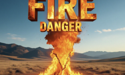 A viral, hyper-realistic YouTube thumbnail with a dramatic wildfire vibe atmosphere. The background is a bone-dry Colorado western slope landscape with dead brown grass and distant mountains under a clear blue sky with intense golden hour lighting. The composition uses a dramatic low angle to focus on the main subject: a massive glowing orange flame shaped like the state of Colorado rising from the ground. Image size should be 3:2. The image features massive 3D typography with strict hierarchy: The Primary Text reads exactly: 'FIRE DANGER'. This text is massive, the largest element in the frame, rendered in blazing molten metal with real flames and sparks to look like a high-budget 3D render. The Secondary Text reads exactly: 'Winds to 30 mph Tuesday'. This text is significantly smaller, positioned below the main text. It features a thick, bright red border/outline (sticker style) to contrast against the background. Make sure text 2 is always different theme, style, effect and border compared to text 1. The text materials correspond to the story's concept. Crucial Instruction: There is absolutely NO other text, numbers, watermarks, or subtitles in this image other than these two specific lines. 8k, Unreal Engine 5, cinematic render.