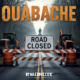 A viral, hyper-realistic YouTube thumbnail with a rugged Indiana outdoors atmosphere. The background is a misty early-spring forest road blocked by orange construction barriers and heavy equipment, with the historic CCC statue barely visible through the trees. The composition uses a dramatic low-angle shot looking up the closed entrance road to focus on the main subject: a massive, weathered "ROAD CLOSED" sign on steel barricades. Image size should be 3:2. The image features massive 3D typography with strict hierarchy: The Primary Text reads exactly: 'Ouabache Closed'. This text is massive, the largest element in the frame, rendered in weathered rust-orange steel to look like a high-budget 3D render. The Secondary Text reads exactly: 'Detour Starts Now'. This text is significantly smaller, positioned below the main text. It features a thick, glowing white border/outline (sticker style) to contrast against the background. Make sure text 2 is always different theme, style, effect and border compared to text 1.