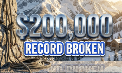 A viral, hyper-realistic YouTube thumbnail with a Kinetic Sports atmosphere. The background is a snowy, sun-drenched mountain campus in Gunnison with dramatic morning lighting. The composition uses a Low Angle to focus on the main subject: a Climbing Carabiner and Rope. Image size should be 3:2. The image features massive 3D typography with strict hierarchy: The Primary Text reads exactly: '$200,000'. This text is massive, the largest element in the frame, rendered in Chrome to look like a high-budget 3D render. The Secondary Text reads exactly: 'RECORD BROKEN'. This text is significantly smaller, positioned below or next to the main text. It features a thick, distinct color border/outline (sticker style) to contrast against the background. Make sure text 2 is always different theme, style, effect and border compared to text 1.