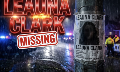 A viral, hyper-realistic YouTube thumbnail with a tense, dramatic crime-alert atmosphere. The background is a dark, rainy Fort Wayne street at night with flashing blue and red police lights cutting through fog and rain. The composition uses a low-angle shot to focus on the main subject: a large, weathered missing person poster taped to a street pole, photo area deliberately darkened to remain faceless. Image size should be 3:2. The image features massive 3D typography with strict hierarchy: The Primary Text reads exactly: 'LEAUNA CLARK'. This text is massive, the largest element in the frame, rendered in glowing red chrome with dramatic lens flare to look like a high-budget 3D render. The Secondary Text reads exactly: 'MISSING'. This text is significantly smaller, positioned below the main text. It features a thick white border with red outline (sticker style) to contrast against the dark background. Make sure text 2 is always different theme, style, effect and border compared to text 1.