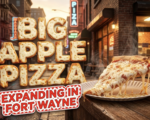 A viral, hyper-realistic YouTube thumbnail with a warm, inviting foodie atmosphere. The background is a bustling urban street corner at golden hour with glowing neon signs reflecting off rain-kissed asphalt and a cozy brick storefront with warm interior light spilling out. The composition uses a low angle to focus on the main subject: a massive, steaming New York-style pizza slice on a classic paper plate, cheese stretching dramatically, sitting on a rustic wooden counter with no human faces visible. Image size should be 3:2. The image features massive 3D typography with strict hierarchy: The Primary Text reads exactly: 'BIG APPLE PIZZA'. This text is massive, the largest element in the frame, rendered in molten mozzarella cheese with golden crispy crust edges to look like a high-budget 3D render. The Secondary Text reads exactly: 'EXPANDING IN FORT WAYNE'. This text is significantly smaller, positioned below the main text. It features a thick red and white checkered border outline in a retro diner sticker style to contrast against the warm background. The text materials correspond to the story's concept. Crucial Instruction: There is absolutely NO other text, numbers, watermarks, or subtitles in this image other than these two specific lines. 8k, Unreal Engine 5, cinematic render.