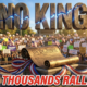 A viral, hyper-realistic YouTube thumbnail with a civic protest atmosphere charged with patriotic energy. The background is a sprawling outdoor park amphitheater filled with a sea of blurred protest signs and American flags under a bright Colorado blue sky with dramatic golden-hour sunlight casting long shadows. The composition uses a low angle to focus on the main subject: a massive bronze-textured replica of the U.S. Constitution scroll unfurling dramatically, placed on a stone pedestal with red, white, and blue ribbons swirling around it. Image size should be 3:2. The image features massive 3D typography with strict hierarchy: The Primary Text reads exactly: 'NO KINGS'. This text is massive, the largest element in the frame, rendered in weathered bronze and stone material with patriotic cracks revealing glowing blue light underneath, to look like a high-budget 3D render. The Secondary Text reads exactly: 'THOUSANDS RALLY'. This text is significantly smaller, positioned below the main text. It features a thick bright red border and white outline in a sticker style to contrast sharply against the golden-lit background. The text materials correspond to the story's concept of democratic resistance and civic power. Crucial Instruction: There is absolutely NO other text, numbers, watermarks, or subtitles in this image other than these two specific lines. 8k, Unreal Engine 5, cinematic render