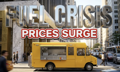 A viral, hyper-realistic YouTube thumbnail with a Gold and Marble Business atmosphere. The background is a busy city street corner with bright afternoon sunlight Lighting. The composition uses a Low Angle to focus on the main subject: a Detailed Faceless bright yellow mobile food truck. Image size should be 3:2. The image features massive 3D typography with strict hierarchy: The Primary Text reads exactly: 'FUEL CRISIS'. This text is massive, the largest element in the frame, rendered in glossy Chrome material to look like a high-budget 3D render. The Secondary Text reads exactly: 'PRICES SURGE'. This text is significantly smaller, positioned below or next to the main text. It features a thick, distinct red color border and outline sticker style to contrast against the background. Make sure text 2 is always different theme, style, effect and border compared to text 1. The text materials correspond to the story's concept. Crucial Instruction: There is absolutely NO other text, numbers, watermarks, or subtitles in this image other than these two specific lines. 8k, Unreal Engine 5, cinematic render.