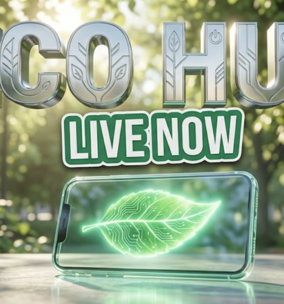 A viral, hyper-realistic YouTube thumbnail with a Sleek Tech atmosphere. The background is a vibrant city park with soft sunlight filtering through green leaves. The composition uses a Low Angle to focus on the main subject: a glowing transparent smartphone displaying a glowing green leaf. Image size should be 3:2. The image features massive 3D typography with strict hierarchy: The Primary Text reads exactly: 'ECO HUB'. This text is massive, the largest element in the frame, rendered in bright Chrome to look like a high-budget 3D render. The Secondary Text reads exactly: 'LIVE NOW'. This text is significantly smaller, positioned below or next to the main text. It features a thick, distinct color border/outline (sticker style) to contrast against the background. Make sure text 2 is always different theme, style, effect and border compared to text 1. The text materials correspond to the story's concept. Crucial Instruction: There is absolutely NO other text, numbers, watermarks, or subtitles in this image other than these two specific lines. 8k, Unreal Engine 5, cinematic render.