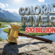 A viral, hyper-realistic YouTube thumbnail with a Business atmosphere. The background is a crystal clear Colorado river winding through a lush green valley with majestic snow capped mountains under a bright sun. The composition uses a Low Angle to focus on the main subject: a massive, gleaming golden gavel resting on a weathered river rock. Image size should be 3:2. The image features massive 3D typography with strict hierarchy: The Primary Text reads exactly: 'COLORADO RIVERS'. This text is massive, the largest element in the frame, rendered in polished Chrome to look like a high-budget 3D render. The Secondary Text reads exactly: '$10 BILLION BILL'. This text is significantly smaller, positioned below the main text. It features a thick, bright red sticker style outline to contrast against the blue water background. The text materials correspond to the story's concept of high cost and legal weight. Crucial Instruction: There is absolutely NO other text, numbers, watermarks, or subtitles in this image other than these two specific lines. 8k, Unreal Engine 5, cinematic render.