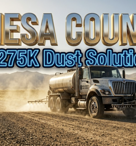 A viral, hyper-realistic YouTube thumbnail with a professional municipal infrastructure atmosphere. The background is a dusty Colorado dirt road stretching toward distant mountains with golden afternoon sunlight and swirling dust particles suspended in the air. The composition uses a low-angle camera perspective to focus on the main subject: a large metal road treatment tanker truck with magnesium chloride spraying equipment visible. The image features massive 3D typography with strict hierarchy: The Primary Text reads exactly: "MESA COUNTY". This text is massive, the largest element in the frame, rendered in shimmering chrome and metallic gold material to look like a high-budget 3D render with real-time reflections. The Secondary Text reads exactly: "275K Dust Solution". This text is significantly smaller, positioned below the primary text, featuring a thick bright blue neon border with a sticker-style outline that contrasts sharply against the dusty background. The text materials correspond to the professional infrastructure concept. Crucial Instruction: There is absolutely no other text, numbers, watermarks, or subtitles in this image other than these two specific lines. 8k, Unreal Engine 5, cinematic render.