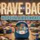 A viral, hyper-realistic YouTube thumbnail with a heartwarming community support atmosphere. The background is a warm, softly lit community center interior with volunteers packing colorful backpacks on wooden tables, blurred bokeh lights creating an emotional glow. The composition uses a slightly elevated angle to focus on the main subject: a bright blue children's backpack sitting open on a table, filled with visible care items including food packages, hygiene products, and handwritten cards with hearts. Image size should be 3:2. The image features massive 3D typography with strict hierarchy: The Primary Text reads exactly: 'BRAVE BAGS'. This text is massive, the largest element in the frame, rendered in soft gradient gold with gentle embossed texture to look like a high-budget 3D render with warmth and hope. The Secondary Text reads exactly: 'HOPE IN A BACKPACK'. This text is significantly smaller, positioned below the main text. It features a thick, distinct white and teal border/outline in sticker style to contrast against the background. Make sure text 2 is always different theme, style, effect and border compared to text 1. The text materials correspond to the story's concept of compassion and community care. Crucial Instruction: There is absolutely NO other text, numbers, watermarks, or subtitles in this image other than these two specific lines. 8k, Unreal Engine 5, cinematic render.