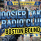 A viral, hyper-realistic YouTube thumbnail with a kinetic, tech-focused atmosphere. The background is a motion-blurred view of the Boston Marathon finish line, filled with cheering crowds and confetti. The composition uses a macro close up to focus on the main subject: a modern, rugged hand-held amateur radio transceiver held by a gloved hand. Image size should be 3:2. The image features massive 3D typography with strict hierarchy: The Primary Text reads exactly: 'HOOSIER LAKES RADIO CLUB'. This text is massive, the largest element in the frame, rendered in polished blue chrome to look like a high-budget 3D render. The Secondary Text reads exactly: 'BOSTON BOUND'. This text is significantly smaller, positioned below the main text. It features a thick, bright yellow border/outline (sticker style) to contrast against the background.