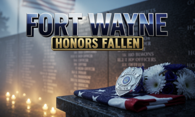 A viral, hyper-realistic YouTube thumbnail with a solemn, patriotic, blue-hour atmosphere. The background is a misty granite memorial wall engraved with officer names along North Wells Street, soft American flag waving in the distance, with cinematic god rays cutting through morning fog and warm candlelight glow at the base. The composition uses a low angle, three quarter view to focus on the main subject: a polished police badge resting on a folded American flag beside a fresh white and blue wreath, raindrops glistening on the metal. Image size should be 3:2. The image features massive 3D typography with strict hierarchy: The Primary Text reads exactly: 'FORT WAYNE'. This text is massive, the largest element in the frame, rendered in brushed chrome steel with a deep navy blue gradient and subtle reflective highlights to look like a high-budget 3D render. The Secondary Text reads exactly: 'HONORS FALLEN'. This text is significantly smaller, positioned below the main text. It features a thick gold sticker style border with a matte black fill, contrasting sharply against the foggy background. Make sure text 2 is always different theme, style, effect and border compared to text 1. The text materials correspond to the story's concept of duty, sacrifice, and remembrance. Crucial Instruction: There is absolutely NO other text, numbers, watermarks, or subtitles in this image other than these two specific lines. 8k, Unreal Engine 5, cinematic render.